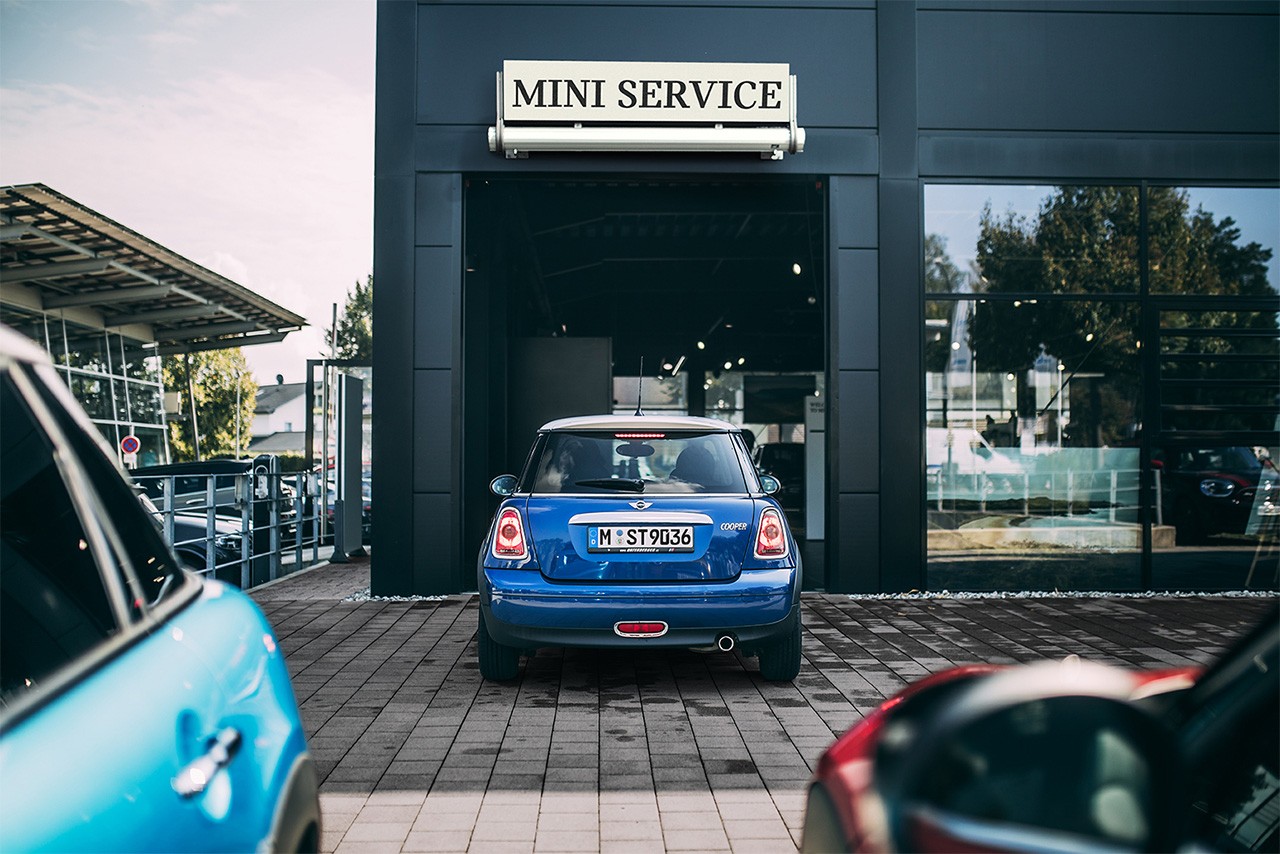 MINI Cooper in Electric Blue parked at a MINI Service entrance, rear exterior view